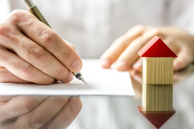 Man signing a contract when buying a new house