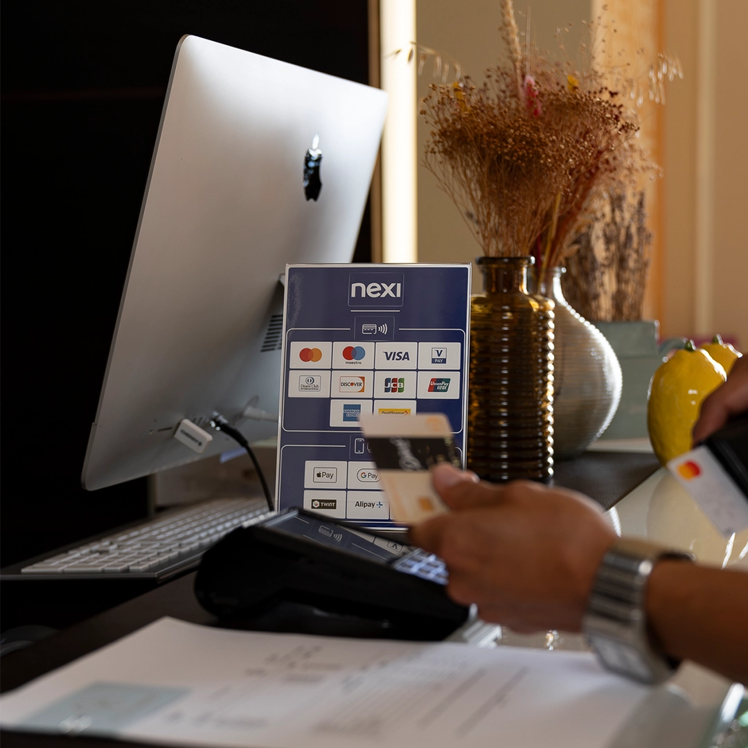 Client réglant un achat par carte bancaire sans contact sur un terminal de paiement Nexi